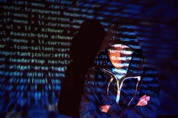 Cyber attack with unrecognizable hooded hacker using virtual reality, digital glitch effect.